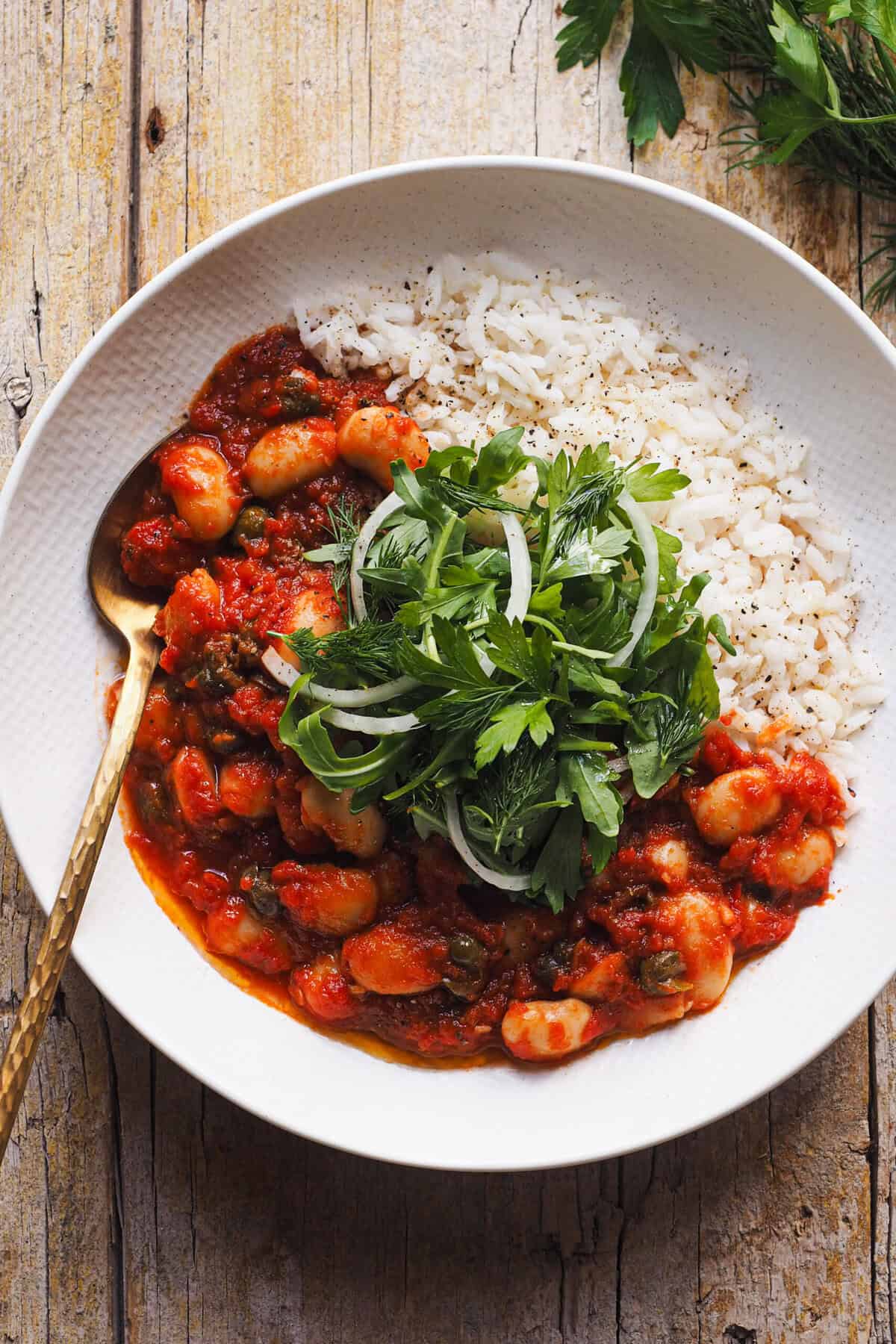 Alubias alla Puttanesca, porque hay salsas que no deberían de quedar relegadas solo a la pasta. Ya verás qué guiso más sabroso puede salir de la despensa, sencillo y lleno de sabor mediterráneo. Es un plato saludable y completo que puedes disfrutar tanto para comer como para cenar sin complicaciones. Lo puedes acompañar con arroz, con otro cereal o con pan, y de un toque fresco como la ensalada que he añadido hoy en lugar del toque final de perejil típico de una puttanesca. ¡Estoy segura que si te animas a hacerlo, esta idea te va a reconciliar con las legumbres! | Receta de Paula's Apron