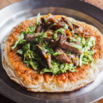 Nueva receta para alegrar tus comidas o cenas: Tacos Fáciles de Secreto Ibérico con Ensalada de Col Green Goddess, Cebolla Caramelizada y Pan Plano. Porque está muy bien hacerse una carne a la plancha y acompañarla de alguna ensalada u otras cosillas, pero todo con pan mejora jeje. Coge los componentes y úsalos juntos como vamos a ver hoy o por separado en otras recetas, haz extra de cada cosa (excepto de carne) y crea mil platos diferentes a partir de este durante el resto de la semana. | Receta de Paula's Apron