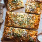 Este pastel de hojaldre relleno de boloñesa de coliflor es como una lasaña envuelta en hojaldre: crujiente por fuera y con un relleno tan sabroso y cremoso que sorprende a cualquiera. Es vegetariano, porque la boloñesa es 100% vegana. Es simplemente una receta reconfortante, diferente y perfectísima para ocasiones especiales como Navidad. | Receta de Paula's Apron