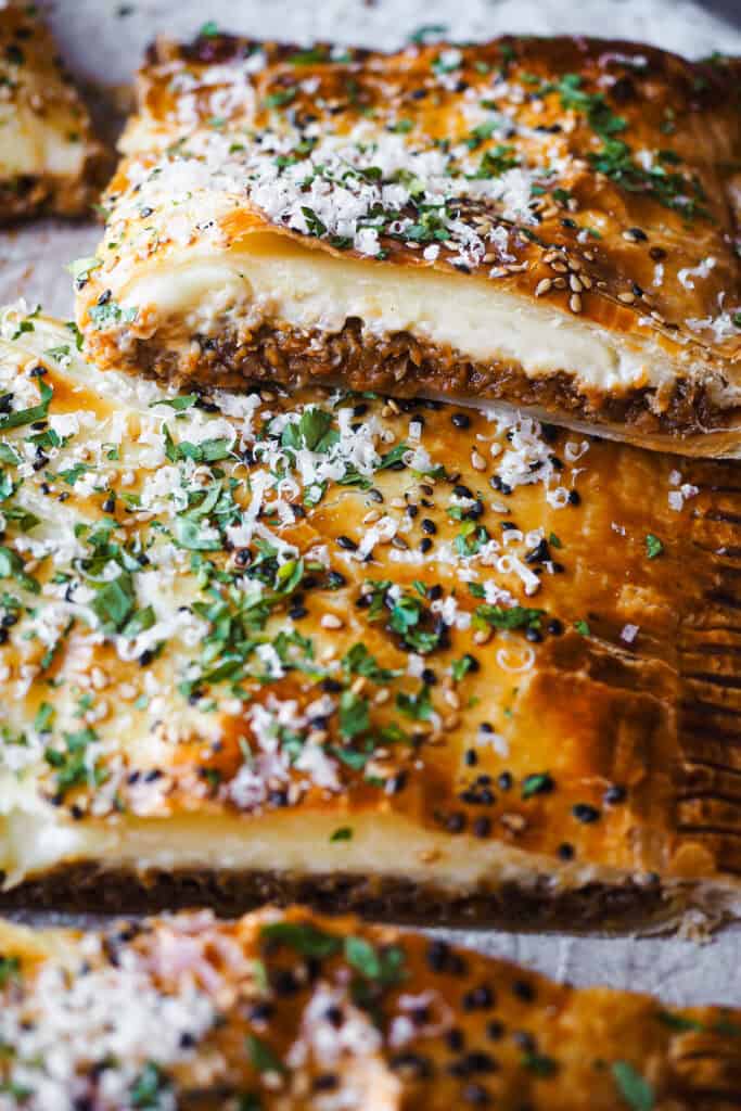 Este pastel de hojaldre relleno de boloñesa de coliflor es como una lasaña envuelta en hojaldre: crujiente por fuera y con un relleno tan sabroso y cremoso que sorprende a cualquiera. Es vegetariano, porque la boloñesa es 100% vegana. Es simplemente una receta reconfortante, diferente y perfectísima para ocasiones especiales como Navidad. | Receta de Paula's Apron