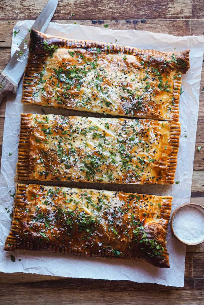 Este pastel de hojaldre relleno de boloñesa de coliflor es como una lasaña envuelta en hojaldre: crujiente por fuera y con un relleno tan sabroso y cremoso que sorprende a cualquiera. Es vegetariano, porque la boloñesa es 100% vegana. Es simplemente una receta reconfortante, diferente y perfectísima para ocasiones especiales como Navidad. | Receta de Paula's Apron