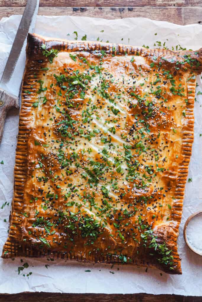 Este pastel de hojaldre relleno de boloñesa de coliflor es como una lasaña envuelta en hojaldre: crujiente por fuera y con un relleno tan sabroso y cremoso que sorprende a cualquiera. Es vegetariano, porque la boloñesa es 100% vegana. Es simplemente una receta reconfortante, diferente y perfectísima para ocasiones especiales como Navidad. | Receta de Paula's Apron