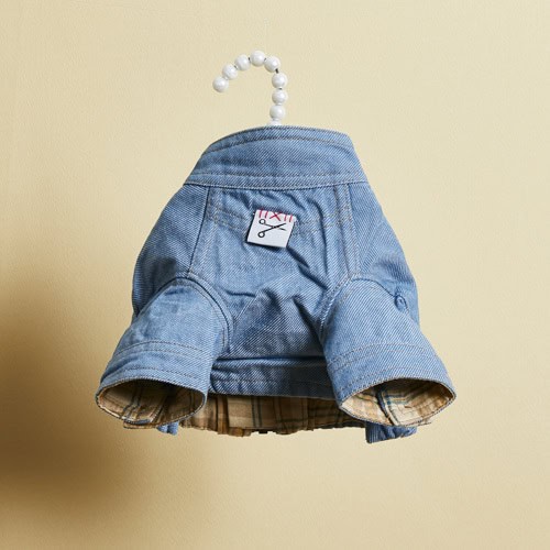 Cute dog denim jacket with plaid lining, designed for pet fashion and style, hanging on a beaded hanger. Perfect for fashionable small dogs to showcase their personality.