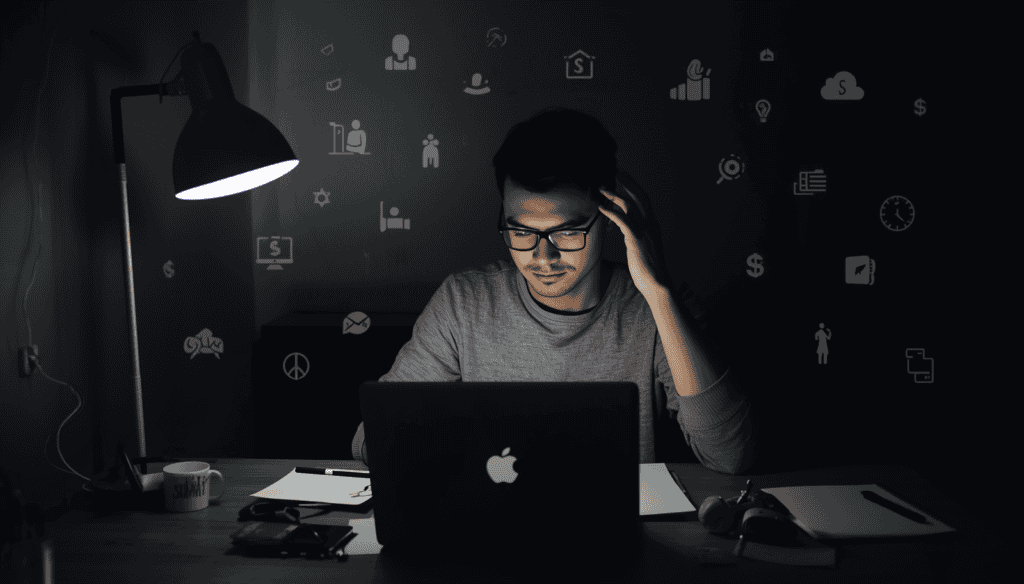 Student working late at desk with laptop and notes, learning online income strategies