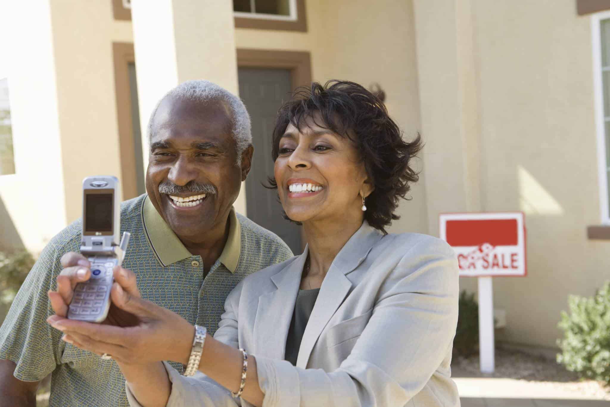 a happy senior couple who have sold their house to PDX Renovations in Portland for a fair price, as‑is, to help their situation.