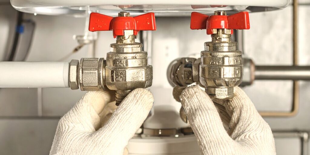 Firefly_Professional plumber's gloved hands inspecting water heater valves for leaks, small w 309830