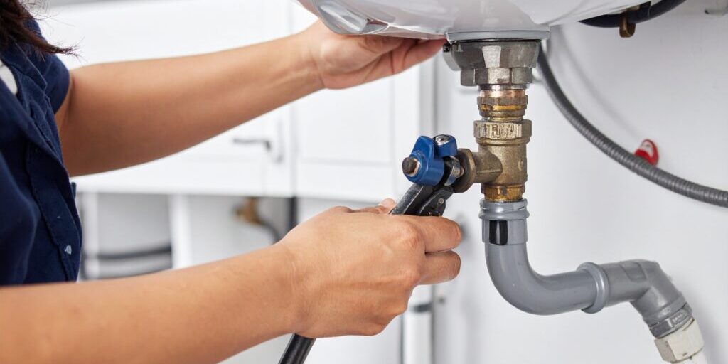 Firefly_Professional plumber's hands connecting a gas line to a residential water heater, det 309830