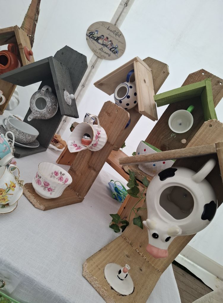 Upcycled wooden bird feeders with charming designs and colourful accents. Perfect for attracting gar.