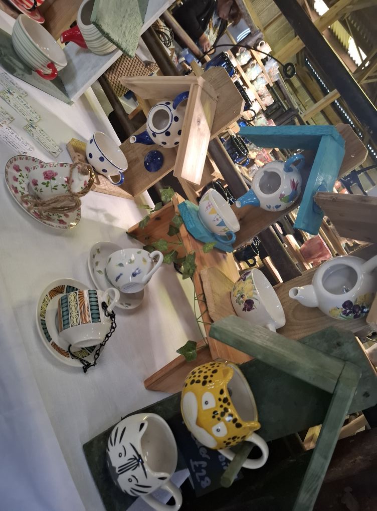 Upcycled wooden bird feeders with colourful painted designs, perfect for attracting garden birds.