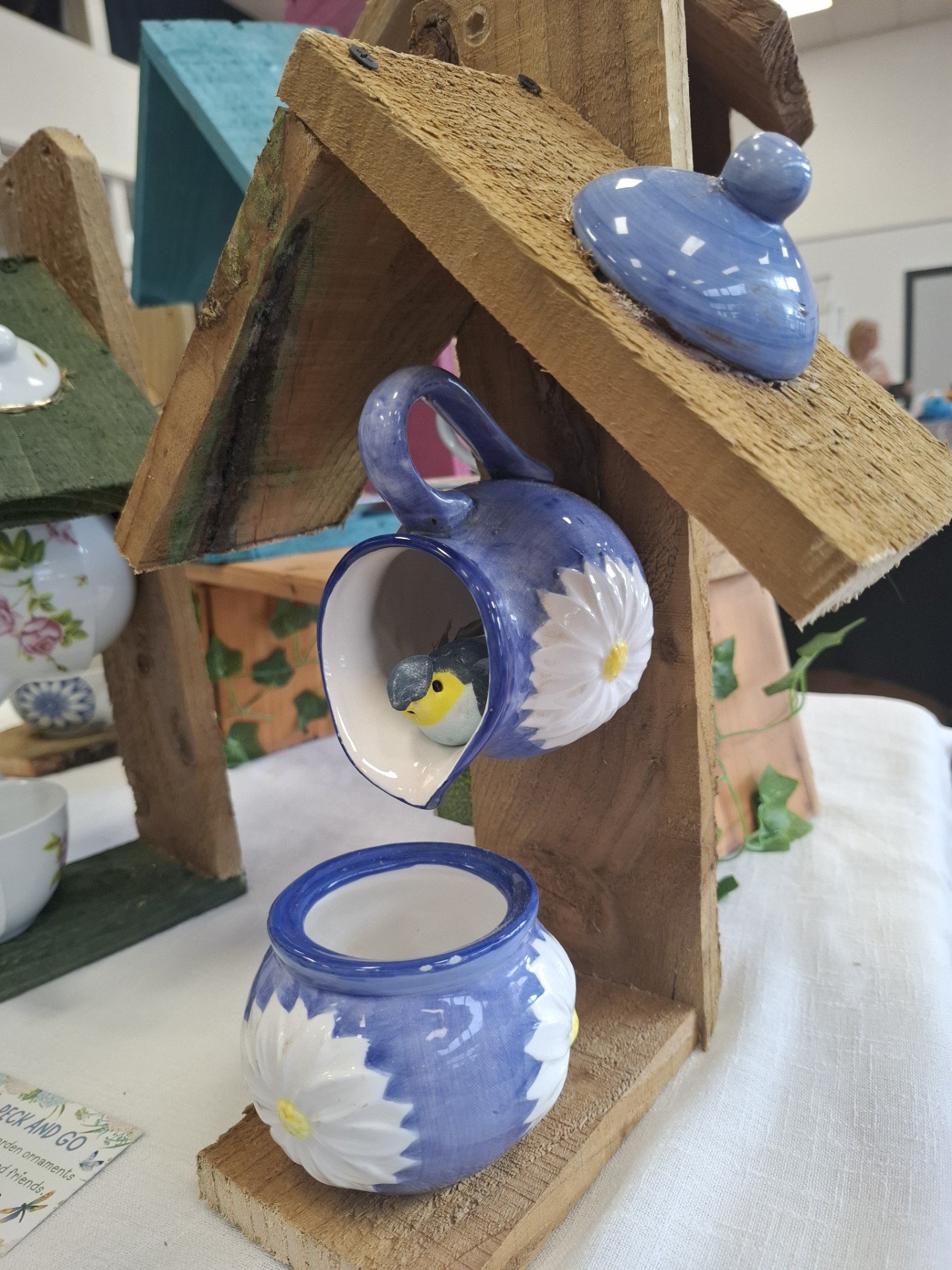 Upcycled ceramic bird feeders with floral designs, perfect for garden birds.