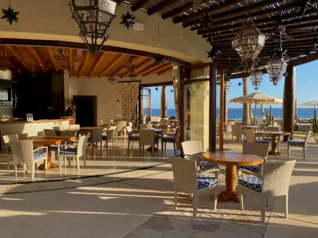 Elegant Pedregal Beachfront Restaurant With Outdoor Seating And Ocean Views, Featuring Natural Wood Accents, Tropical Decor, And A Relaxed, Luxurious Ambiance.
