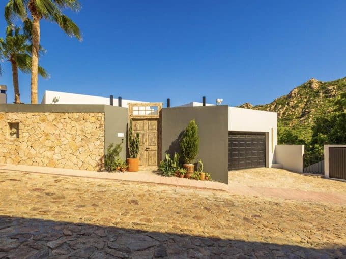 Beautiful Pedregal Home With A Modern Design, Stone Accents, Lush Greenery, And Scenic Mountain Views, Showcasing Sophisticated Architecture And Stylish Outdoor Curb Appeal.