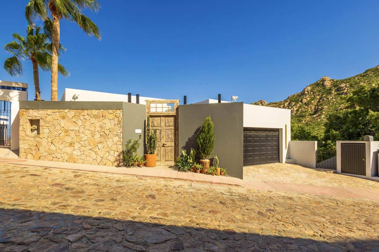 Beautiful Pedregal Home With A Modern Design, Stone Accents, Lush Greenery, And Scenic Mountain Views, Showcasing Sophisticated Architecture And Stylish Outdoor Curb Appeal.