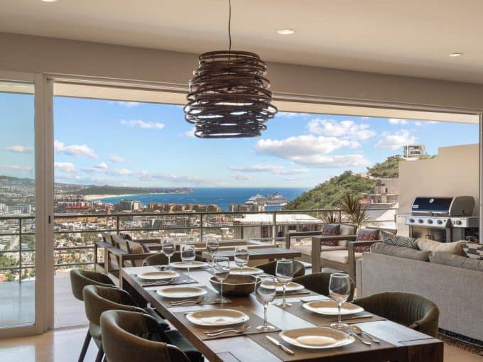 Spectacular Views Of Pedregal, The City, Ocean, And Cruise Ships From A Modern, Open-Concept Dining And Living Area With Glass Doors Opening To A Spacious Balcony.