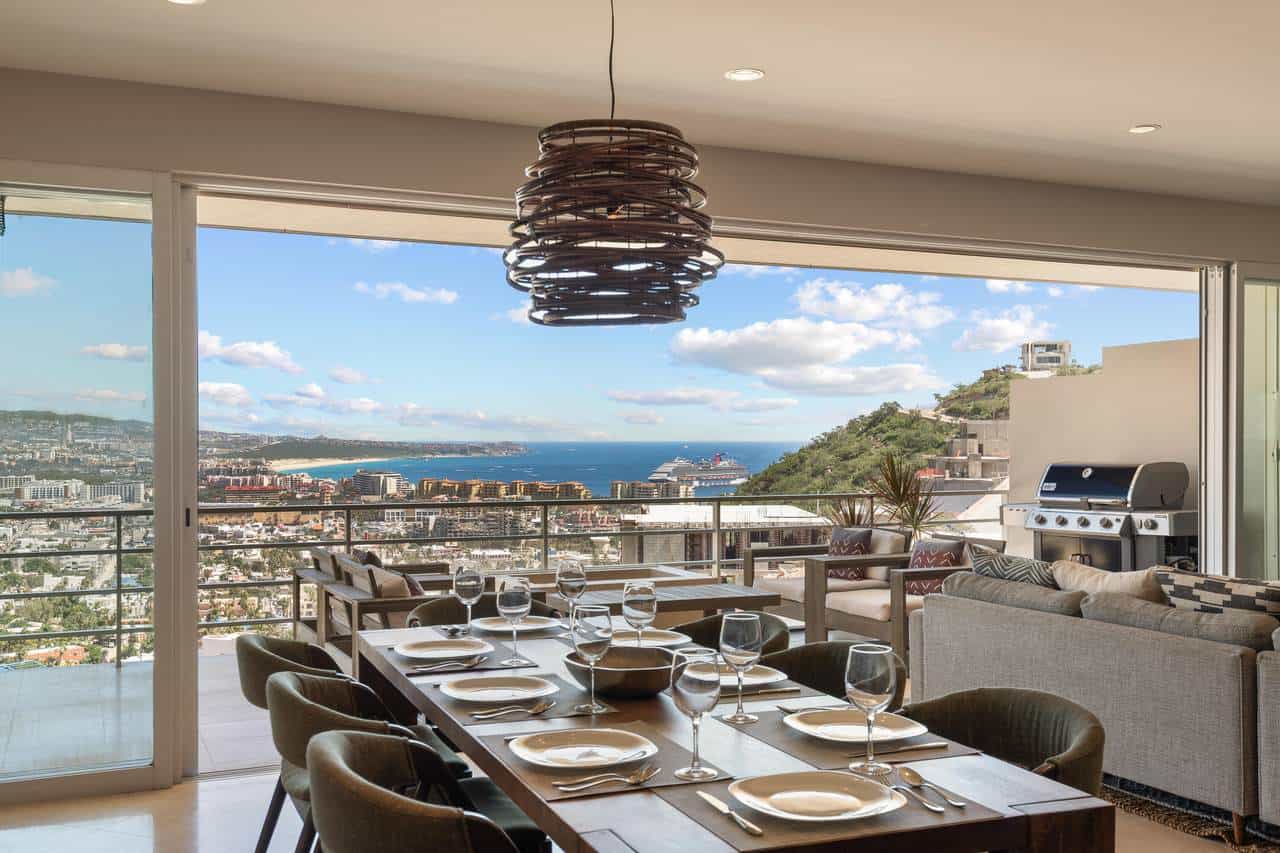 Spectacular Views Of Pedregal, The City, Ocean, And Cruise Ships From A Modern, Open-Concept Dining And Living Area With Glass Doors Opening To A Spacious Balcony.