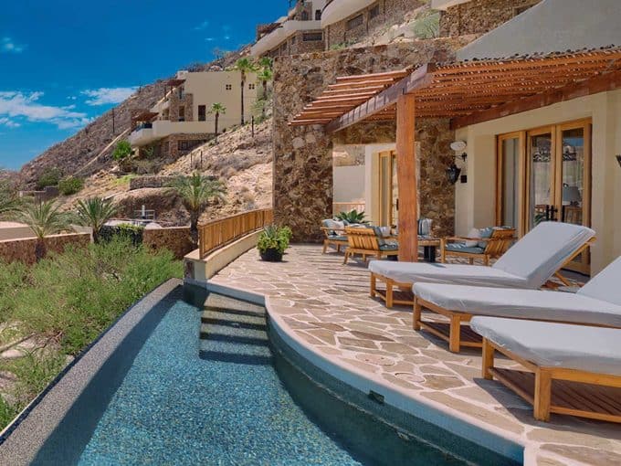 Luxury Pedregal Villa Outdoor Patio With Pool, Lounge Chairs, And Mountain Views, Featuring Natural Stone Architecture And Lush Desert Landscape, Perfect For Upscale Real Estate In Pedregal.