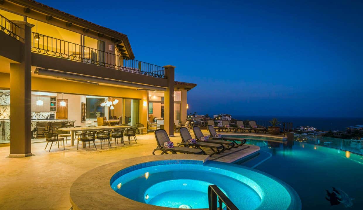 Luxurious Pedregal Estate With Illuminated Infinity Pool And Spacious Outdoor Living Area At Dusk, Offering Stunning Ocean And City Views.