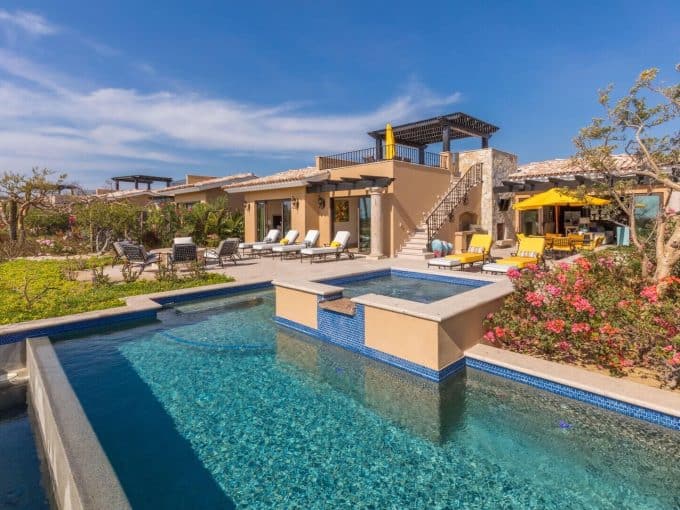 Luxurious Pedregal Waterfront Home Featuring A Sparkling Pool, Outdoor Lounging Area, Lush Landscaping, And Stunning Architecture Perfect For Elegant Outdoor Living.