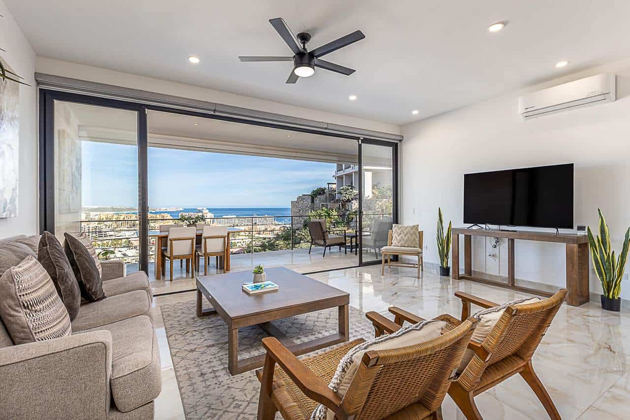 Pedregal Ocean View Hillside Living Room With Modern Decor And Large Glass Doors.