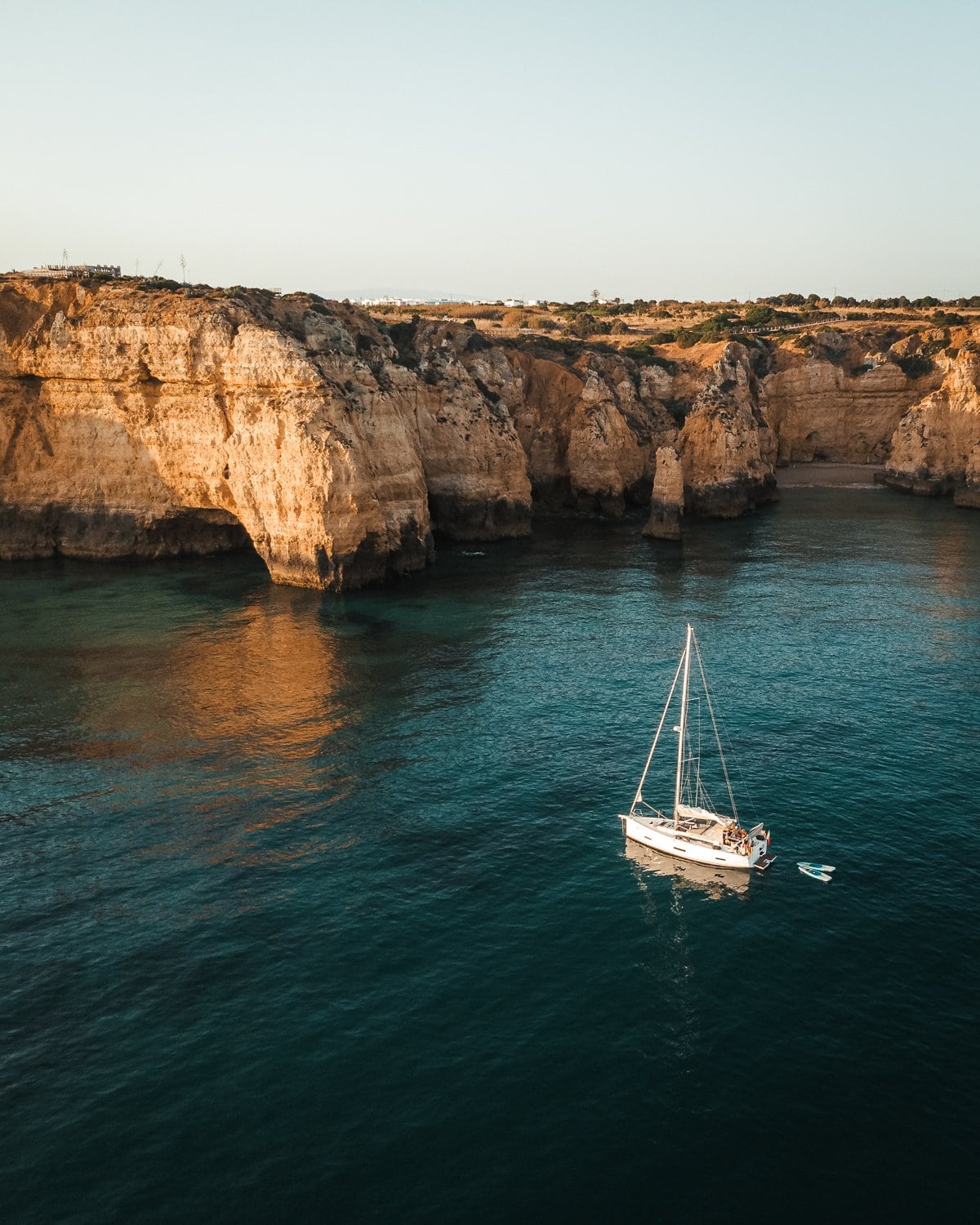 sailboat in the ocean by the cliff