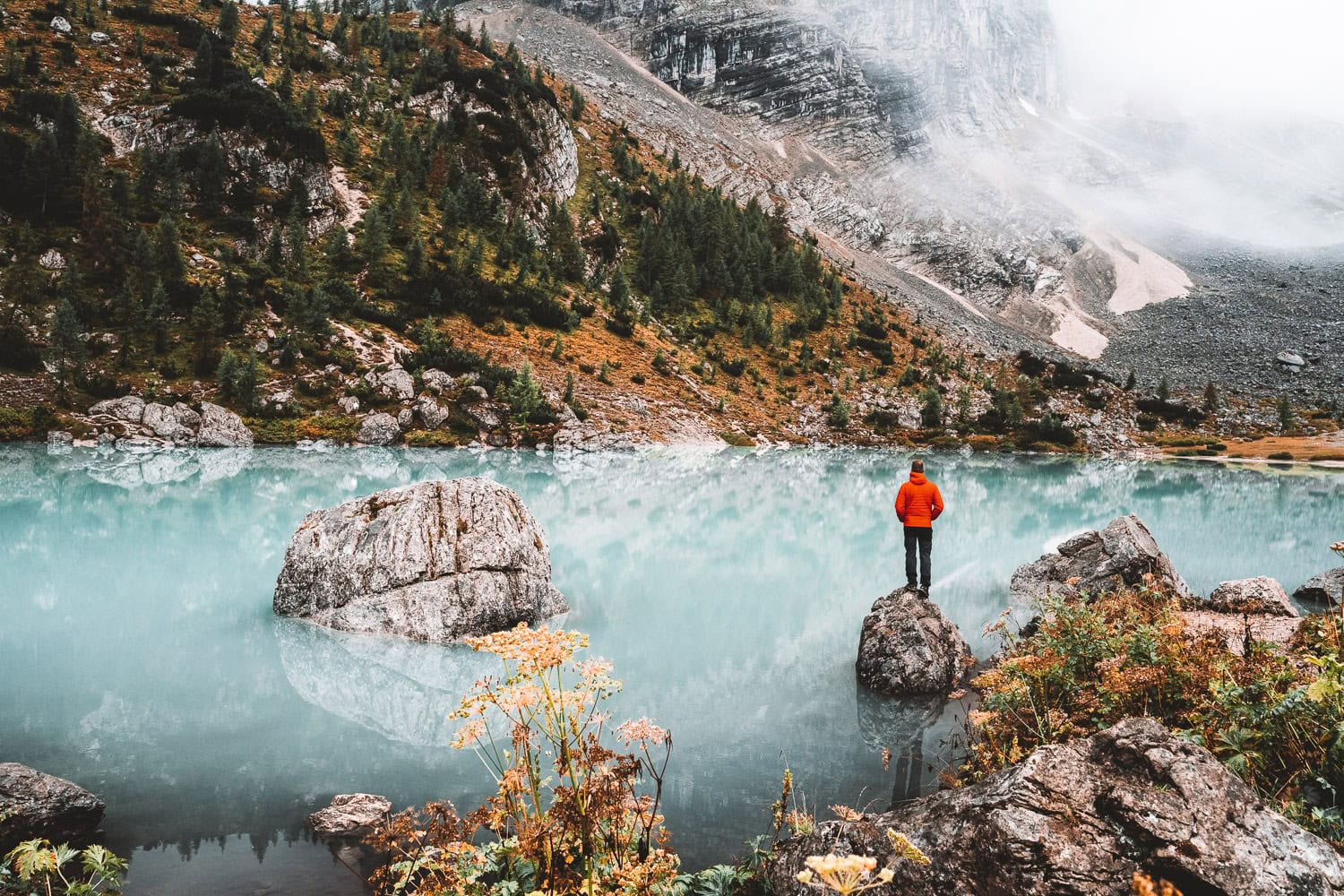 Man standing on a rock on a lake