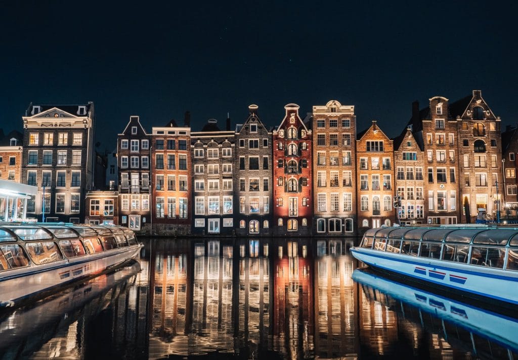 night shot of canal and building in amsterdam