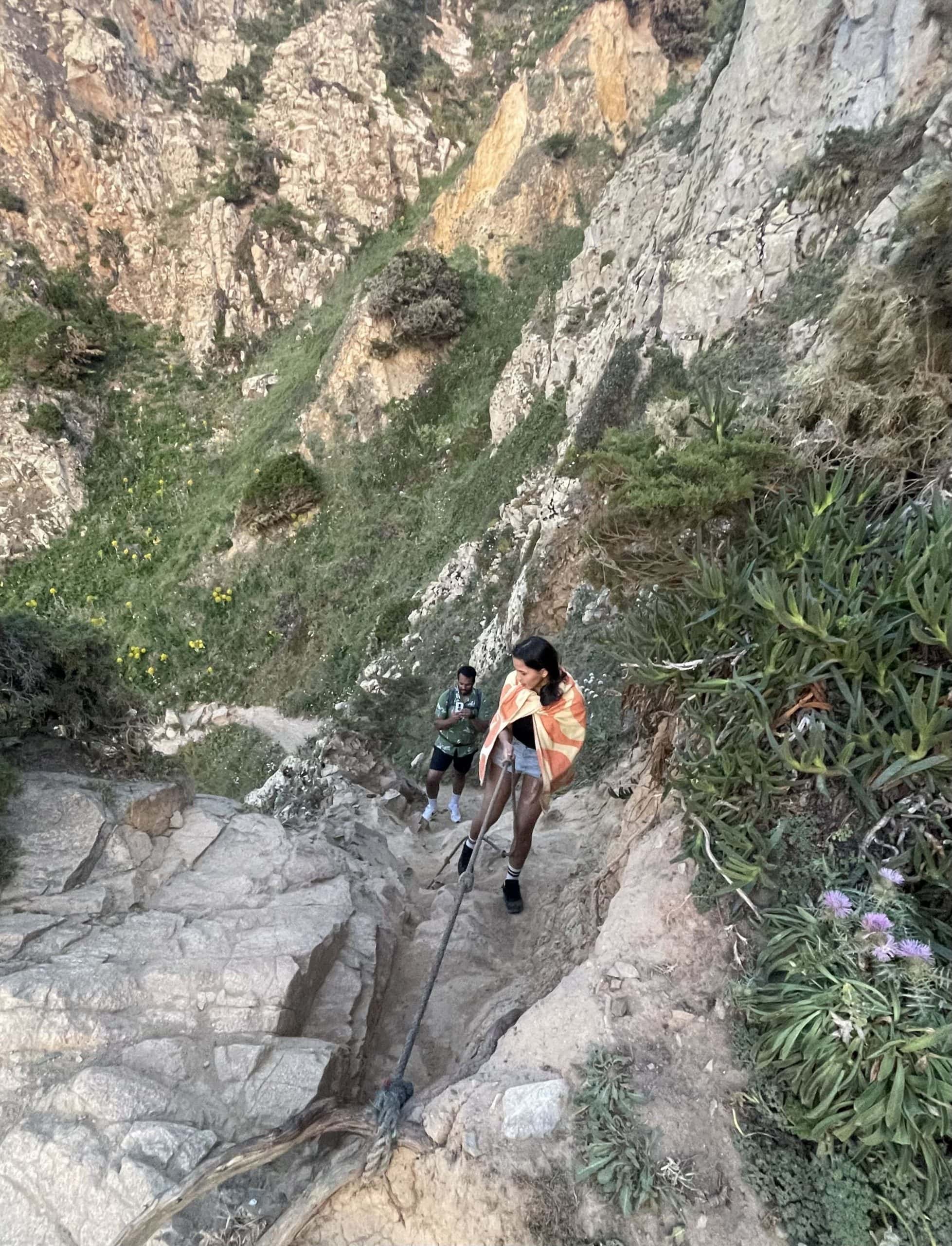 Girl standing by the cliff in Praia Da Ursa