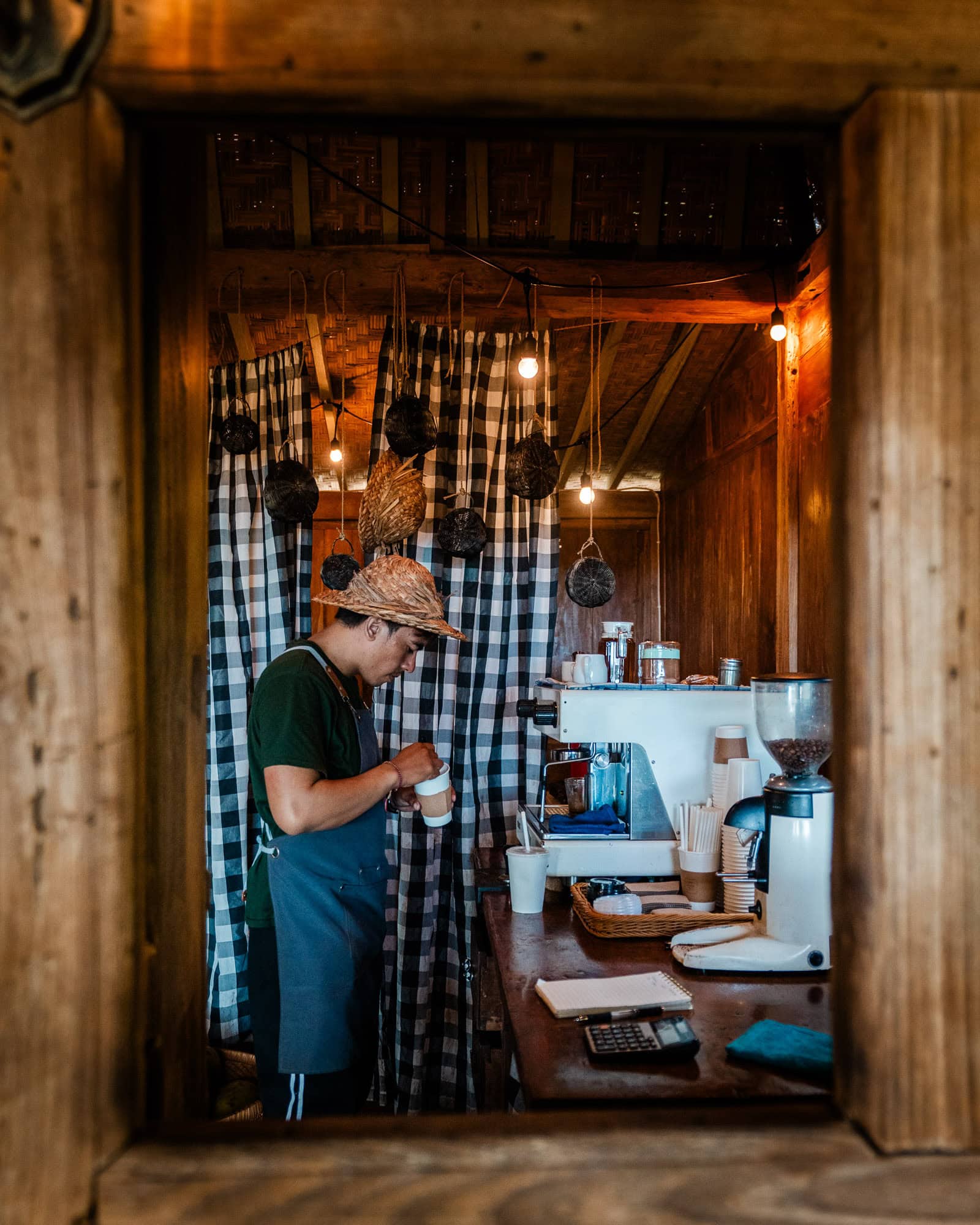 Barista in a small wooden coffee shop