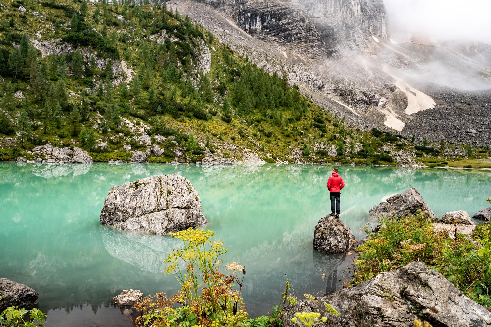 Man standing on a rock at a mountain lake