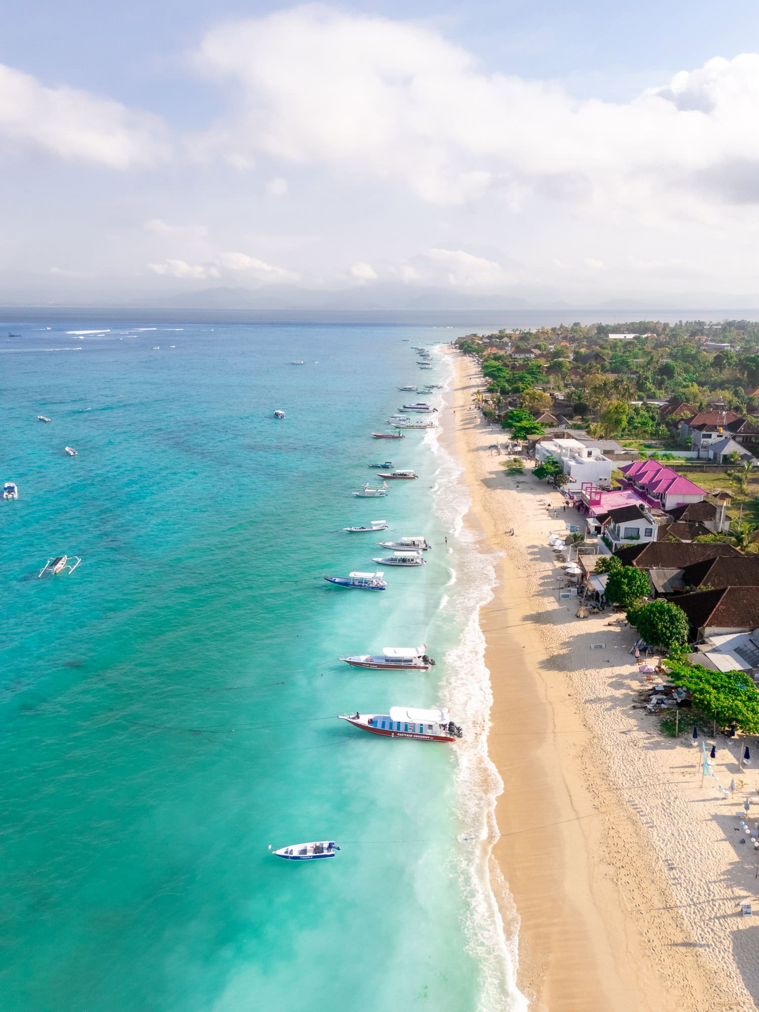 Aerial photo of turquoise waters, boats and a beach