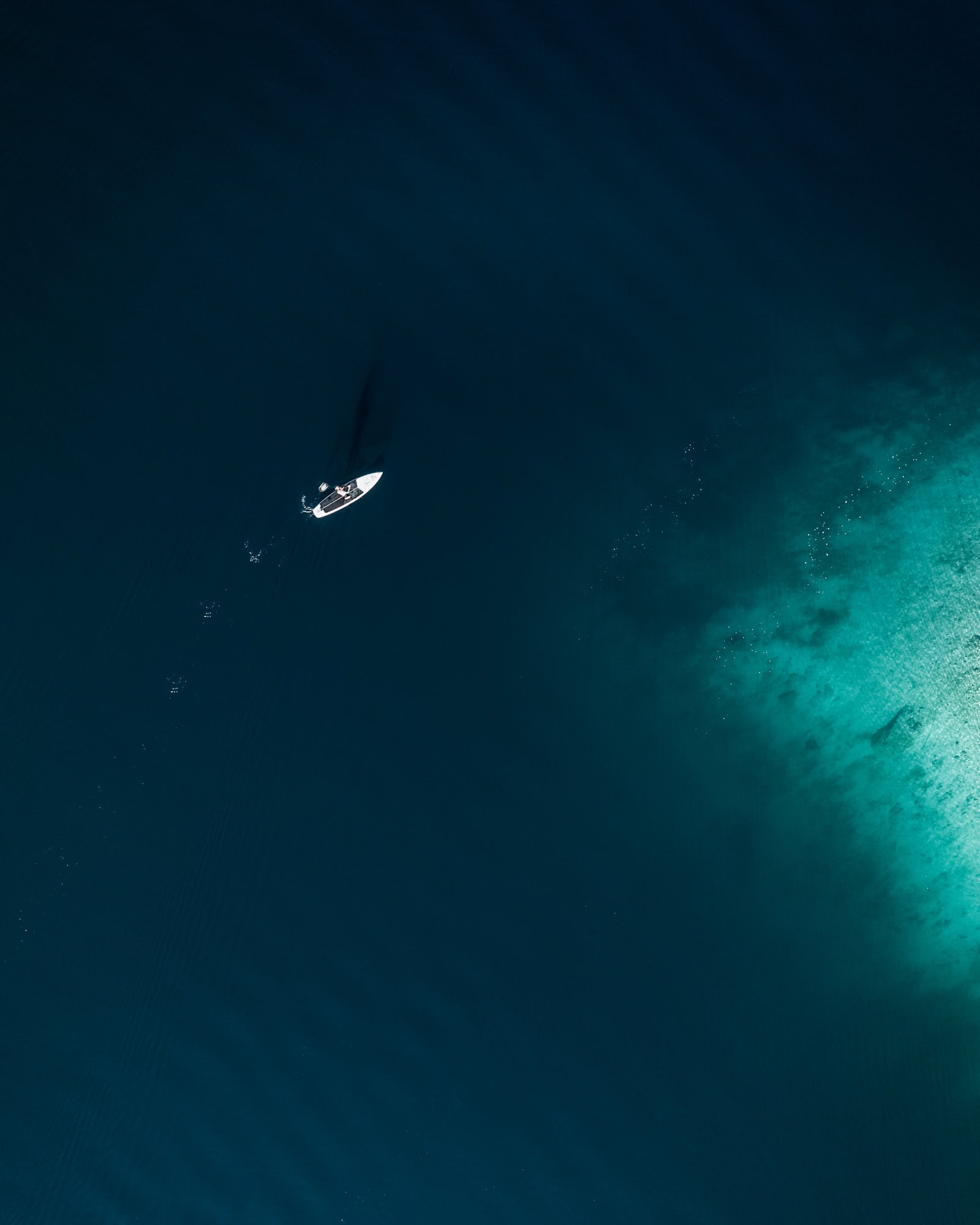 SUP on a turquoise lake from above
