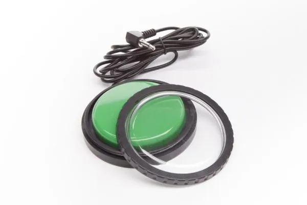 Contacteur vert Libswitch avec un long câble noir, posé sur une surface blanche.