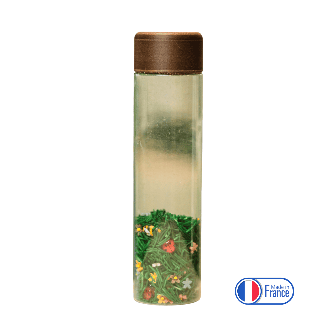 Bouteille sensorielle avec herbe, fleurs et coccinelles miniatures