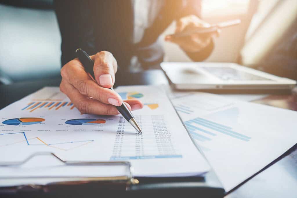 Business professional analyzing financial data with charts and tablet.