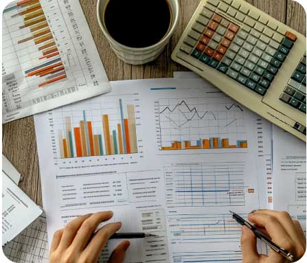 Financial analysis with charts, calculator, and coffee for accounting services at PG Accounting LTD.