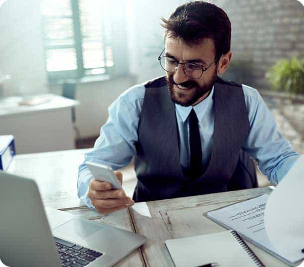 A man working on financial documents at a desk in an office setting.