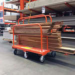 Industrial cart with wooden planks in a hardware store aisle.