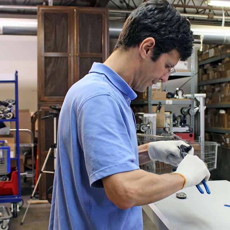 P&H Casters engineer inspecting caster components in workshop.