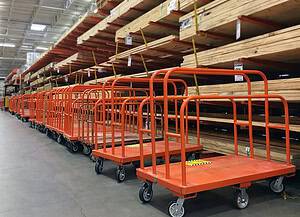 Durable orange carts with polyurethane wheels for efficient hauling in warehouses.
