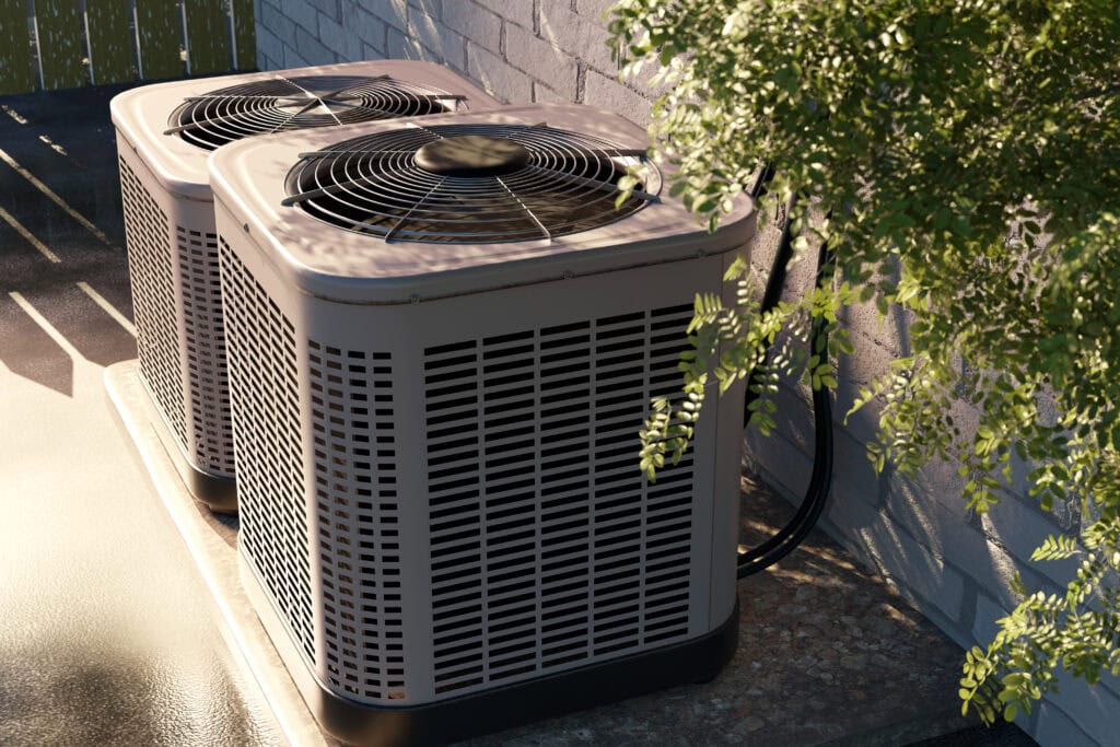 Two outdoor air conditioning units sit side by side on a concrete pad next to a brick wall, partially shaded by nearby foliage—an example of the careful installation you’d expect from experts in HVAC and drain cleaning Philadelphia trusts.