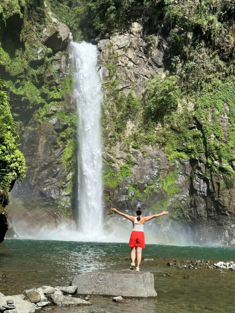 Standing at the base of a mountain waterfall