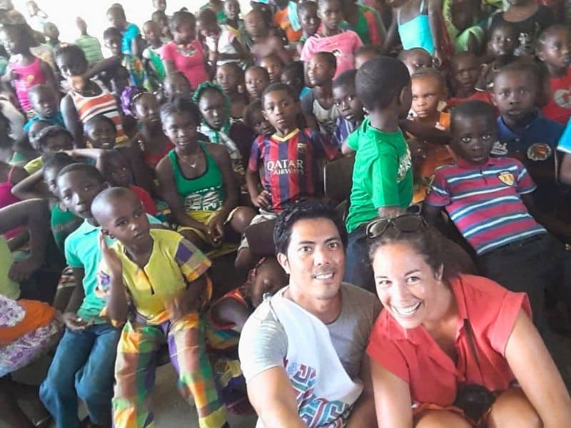 Doctors pose with a group of children inside a community gathering space in Suriname.