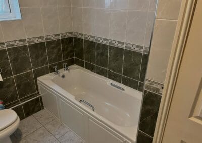 Modern bathroom with bathtub and tiled walls.