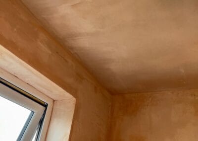 Freshly plastered ceiling and wall corner with window.