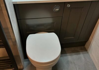 Modern bathroom with gray cabinets and toilet