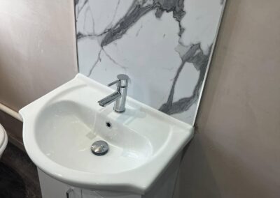 Marble backsplash bathroom sink with cabinet.