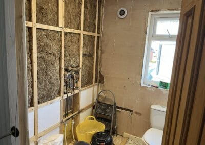 Bathroom renovation with exposed walls and tools.