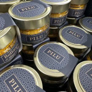 Grated Pilu Bottarga 50g in small glass jars with navy labels and gold lids.