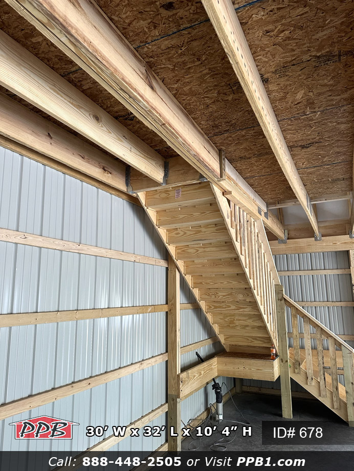 Stairs that go up to an attic floor in a red barn.
