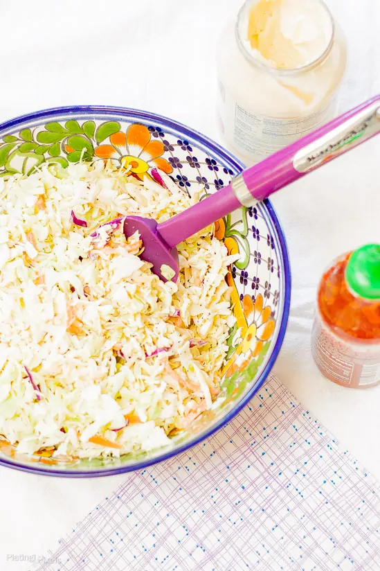 Colorful coleslaw with honey sriracha dressing and fresh ingredients.